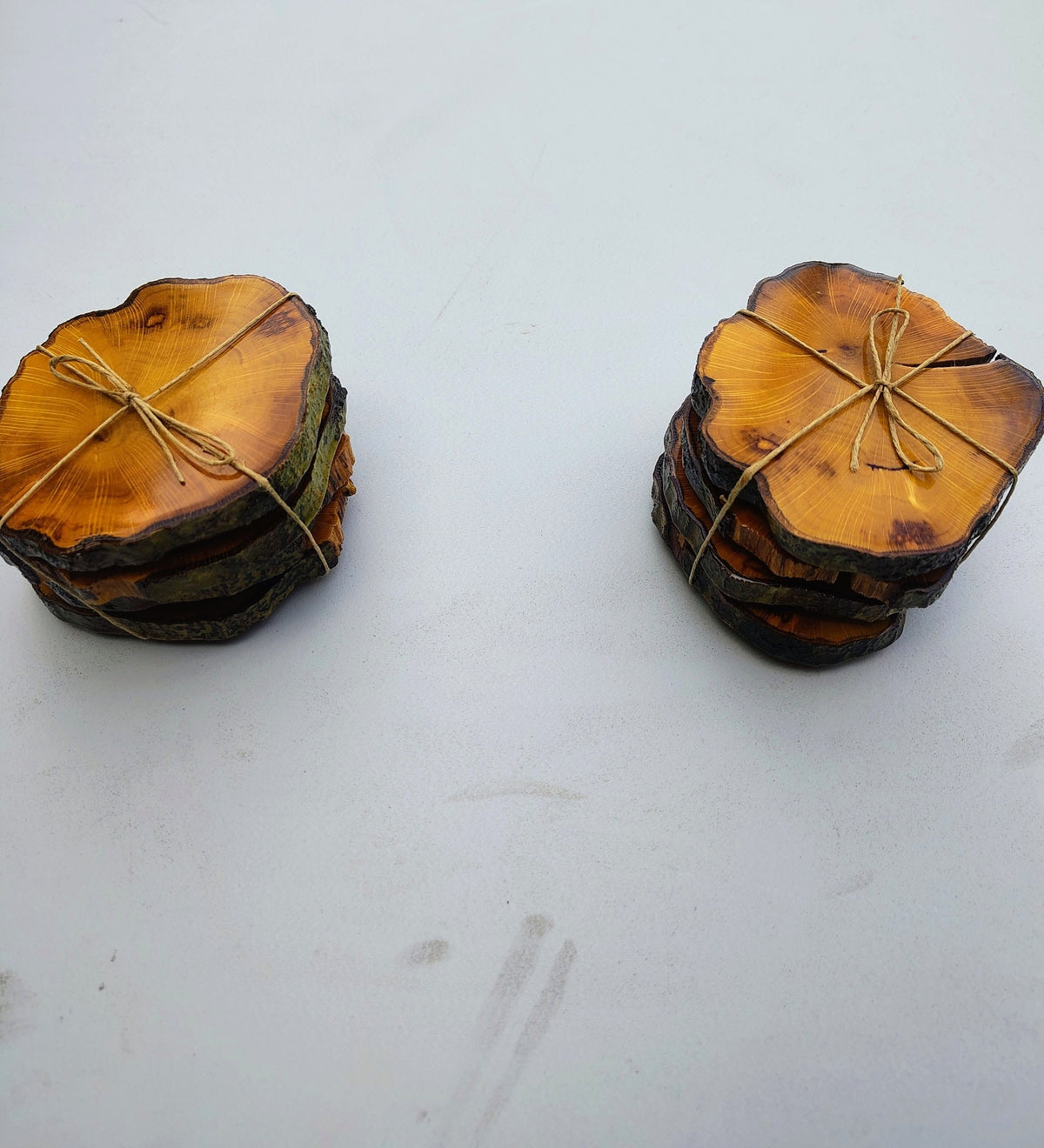 Two stacks of live edge wood coasters tied with twine